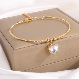 Elegante pulsera de titanio dorado con colgante de corazón de circón y cuentas facetadas