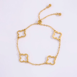 Detailed macro view of golden clover charms and adjustable sliding clasp on the bracelet