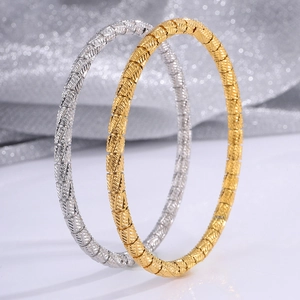 Detailed view of bamboo-style stainless steel bracelets in gold and silver finish