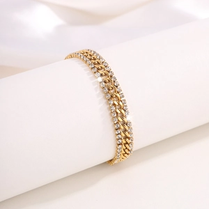 Detailed macro of a triple-layered 18k gold plated Cuban chain bracelet with zircons
