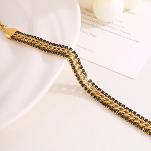 Detail of 18k gold plated Cuban chain bracelet with black cubic zirconia accents