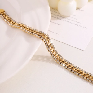 Macro detail of triple-strand gold NK bracelet with glittering pave crystal inlay