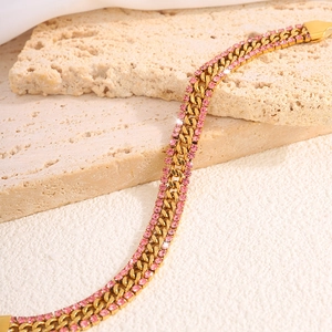 Close-up of gold Cuban chain bracelet with double row pink zircons on elegant fabric