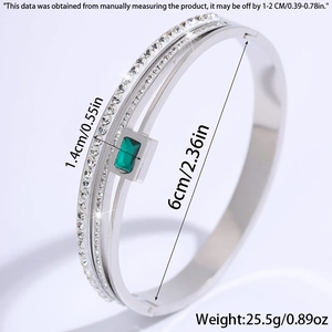 Detailed view of triple-layer stainless steel bangle with emerald green gem and diamonds