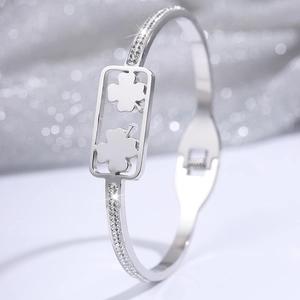 Detail van de zilveren klaverarmband met kristallen inleg op glinsterende achtergrond