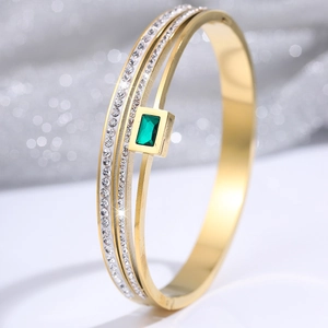 Detailed macro shot of a three-layer gold titanium bracelet with emerald and diamonds
