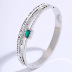Detail of three-layer silver steel bracelet with emerald green stone and zircon inlay