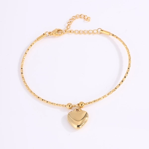 Detalle de pulsera de corazón ajustable en titanio dorado con cadena ondulada y colgante