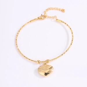 Detalle de pulsera de corazón en acero dorado con cierre de langosta y cadena ajustable