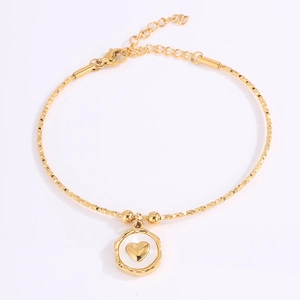 Detalle de pulsera de acero de titanio dorado con cadena de textura y dije de corazón