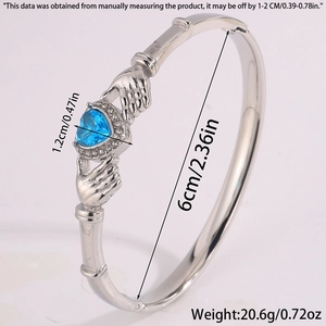 Detailed side view of silver Claddagh cuff bracelet with blue heart stone and diamonds