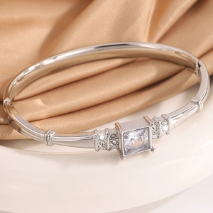 Detailed close-up of a silver titanium steel bracelet with a large square diamond and side pave stones