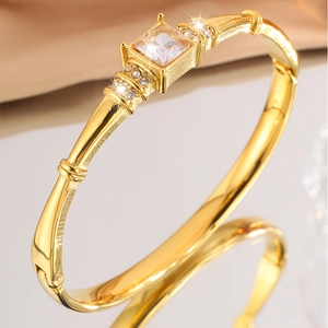 Close-up of gold-plated titanium bracelet featuring a square diamond and bamboo texture