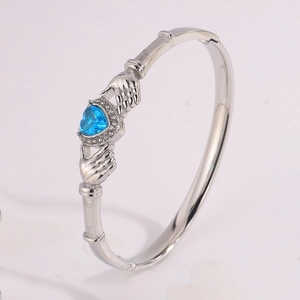 Macro view of Claddagh heart-shaped blue gemstone bracelet with cubic zirconia accents