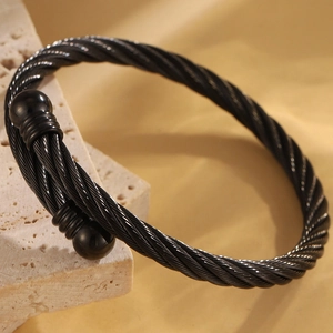 Détail d'un bracelet jonc en acier inoxydable noir torsadé avec texture tressée