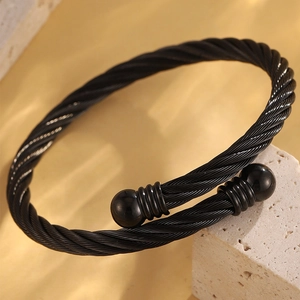 Détail du bracelet torsadé en acier inoxydable noir avec embouts sphériques sur pierre