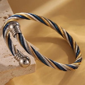 Bracelet manchette torsadé en trois couleurs avec embouts sphériques en or et argent polis
