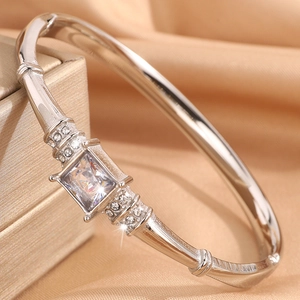 Detail shot of silver bangle featuring a large square zircon and pavé setting on silk