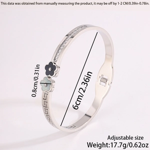 Detail of silver clover hinge bangle with greek fret patterns and cz stone inlay