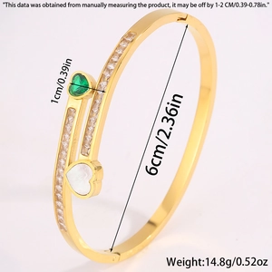 Detail view of gold titanium bangle with green zircon heart and side baguette diamonds