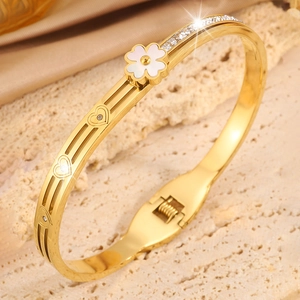 Détails d'un bracelet trèfle doré avec découpes en cœur et cristaux étincelants