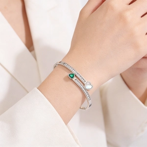Detail of emerald green heart and mother of pearl inlay on silver pavé zircon bracelet