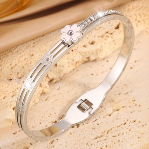 Détail du bracelet trèfle argenté avec cœurs ajourés, zircons et une fleur blanche