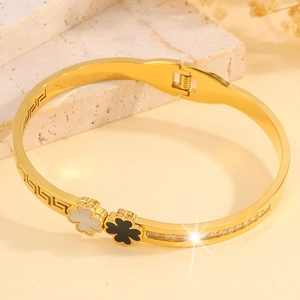Detail view of gold clover bangle with inlaid mother of pearl and meander pattern