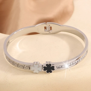 Detailed macro view of silver clover bracelet with Greek meander pattern and zircons