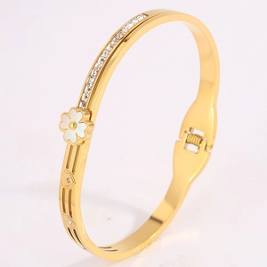 Détail du bracelet trèfle doré en acier titane avec zircons brillants et nacre blanche