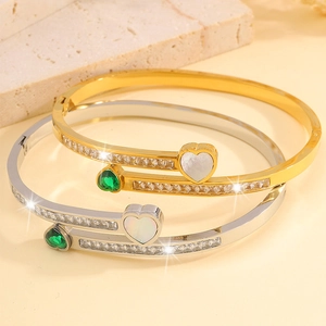 Elegant heart-shaped open bangle in gold and silver finish with sparkling zircons