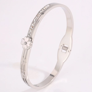 Détail du bracelet trèfle avec strass scintillants et découpes de cœur en métal argenté