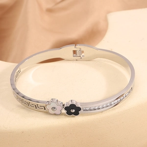 Detail of silver steel bracelet with Greek patterns, flowers and zircon stones