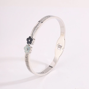 Detail of silver clover bangle with Greek key pattern, enamel flowers and pavé zircon stones