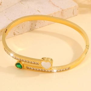Detail of gold-plated double-heart bangle with mother of pearl and emerald green stones