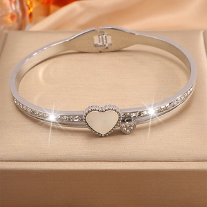 Vue détaillée d'un bracelet jonc argenté avec cœur et zircons sur un écrin à bijoux