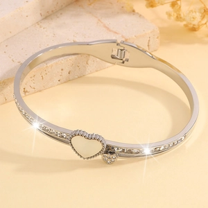 Détail d'un bracelet coeur argenté avec nacre, pavé de strass et fermoir à ressort