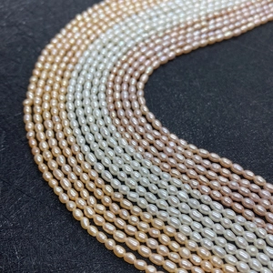 Lustrous white pink and champagne rice-shaped freshwater pearls on a black background
