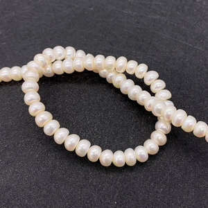 Macro view of natural freshwater rice pearls with high luster on a dark textured background