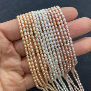 Strands of natural oval freshwater pearls in white, orange, and purple for jewelry DIY
