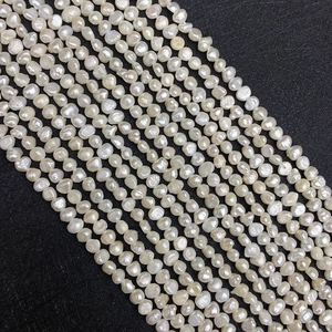 Macro shot of Grade A irregular white baroque freshwater pearls on black textured background