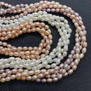 Detailed view of bulk AAA natural rice pearls in white, pink and purple for DIY jewelry
