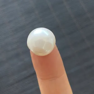 Macro de una perla natural de agua dulce de 13-14mm en la punta del dedo para el tamaño
