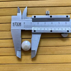 Medición con calibrador del diámetro de 14mm de una perla blanca redonda de agua dulce