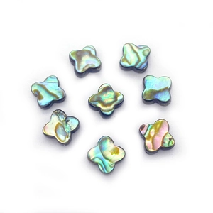 Dettaglio macro di perle di abalone naturale a quadrifoglio con riflessi iridescenti