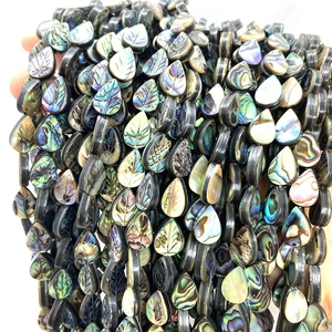 Macro shot of iridescent abalone shell leaf beads with carved veins for DIY jewelry