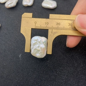 Makroaufnahme einer 13 mm Barock-Süßwasserperle gemessen mit einem Messschieber im Detail