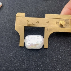 Makroaufnahme einer 18-20mm Barock-Süßwasserperle mit einem Messschieber aus Messing
