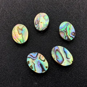 Macro detail of five oval natural abalone shell beads with iridescent rainbow textures