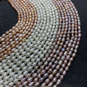 Macro de perles d'eau douce naturelles blanches, roses et violettes sur tissu noir